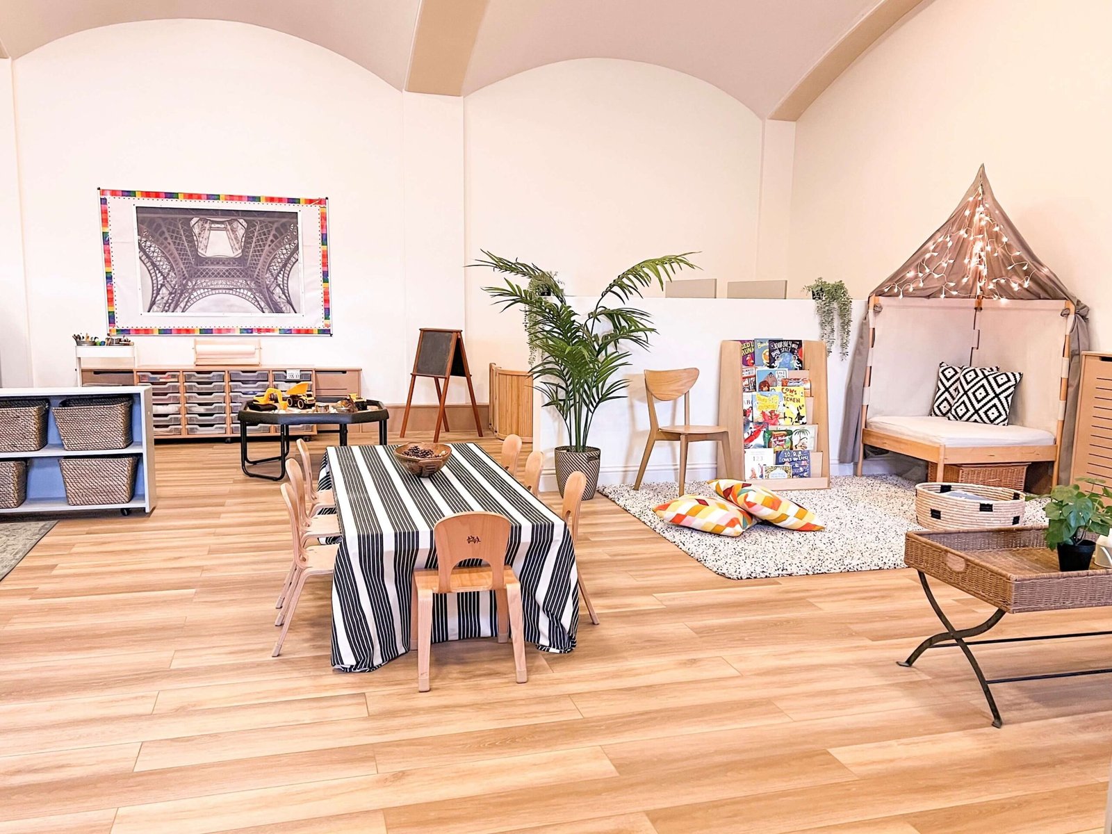 Bright and welcoming classroom at Aplomb Day Nursery Greenford with child-sized tables and play area.